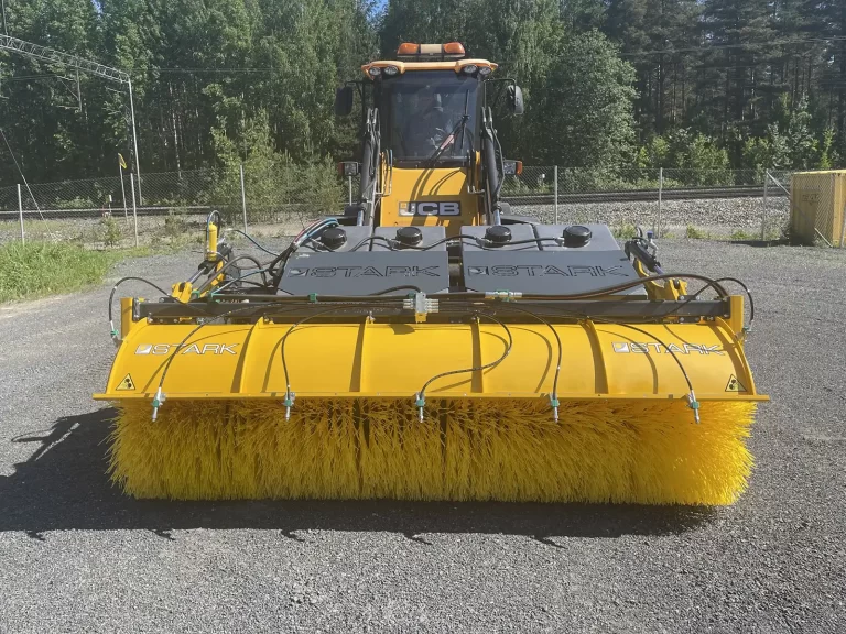 The Stark Bucket Sweeper BSW-S model attached to the operating vehicle and ready to use