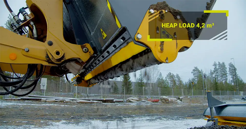 The STARK towable spreader in use shredding icy sand. Text in the picture "Heap load 4,2m^3"